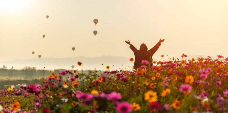 Happy person dancing in field of flowers - what clients look like after Balin Law helps them win their disability case